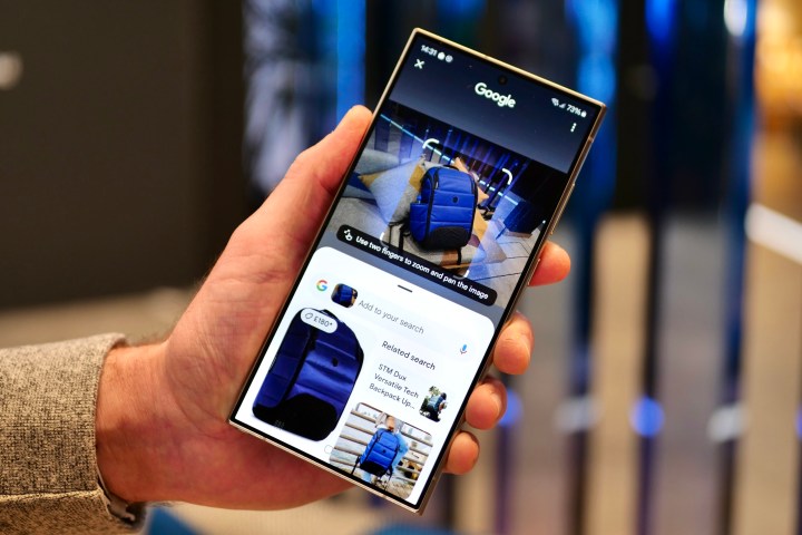 A person holding the Samsung Galaxy S24 Ultra using the Circle to Search feature