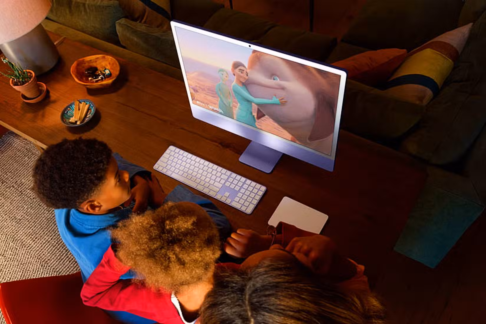 比较:M4 iMac 与 M3 iMac - 新闻和改进 16 配备 Retina 显示屏的 24 英寸 iMac M4,附近的孩子们佩戴着配件,屏幕上播放着动画电影