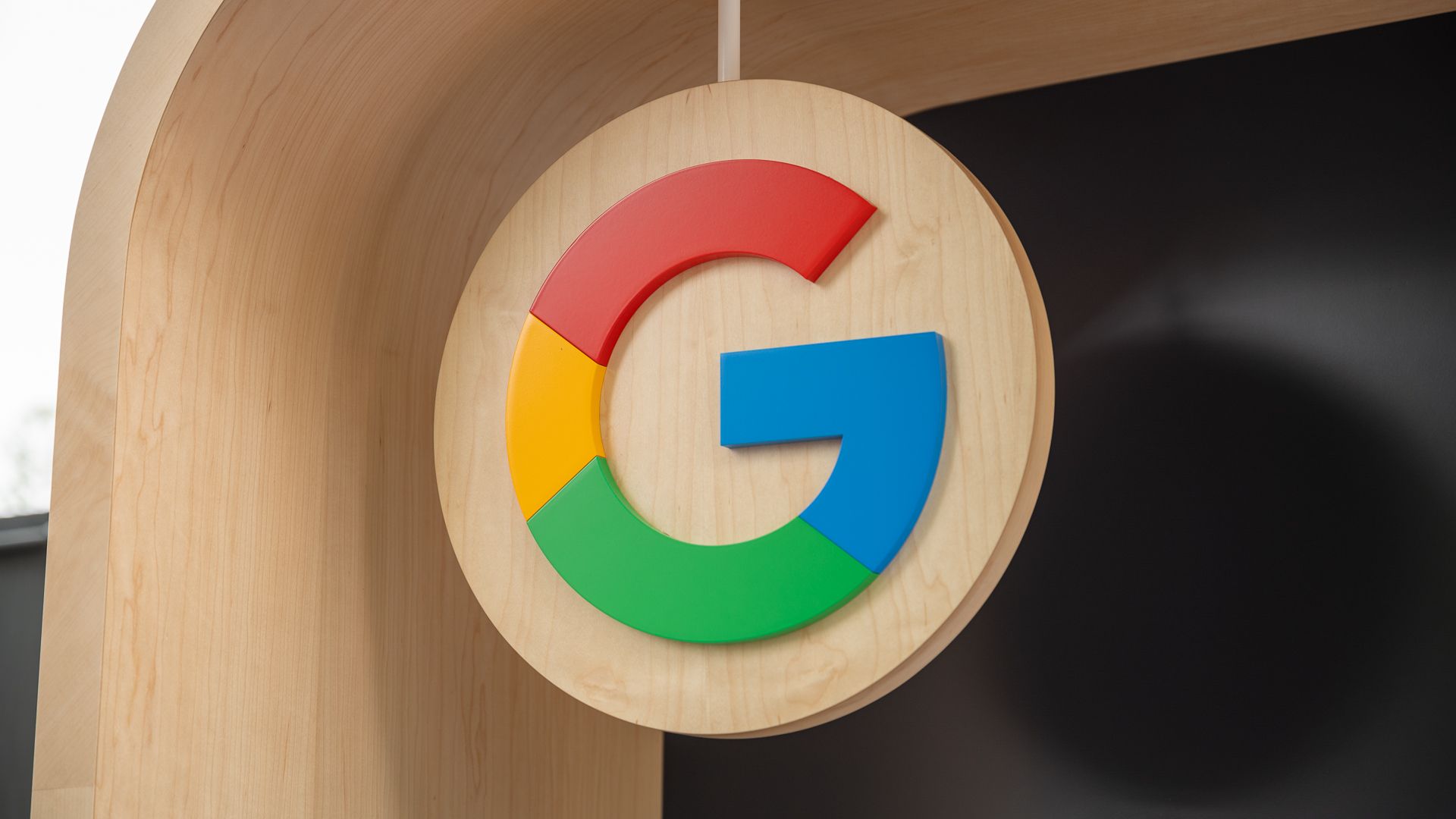 Google G logo on a wooden sign at IO 2023.