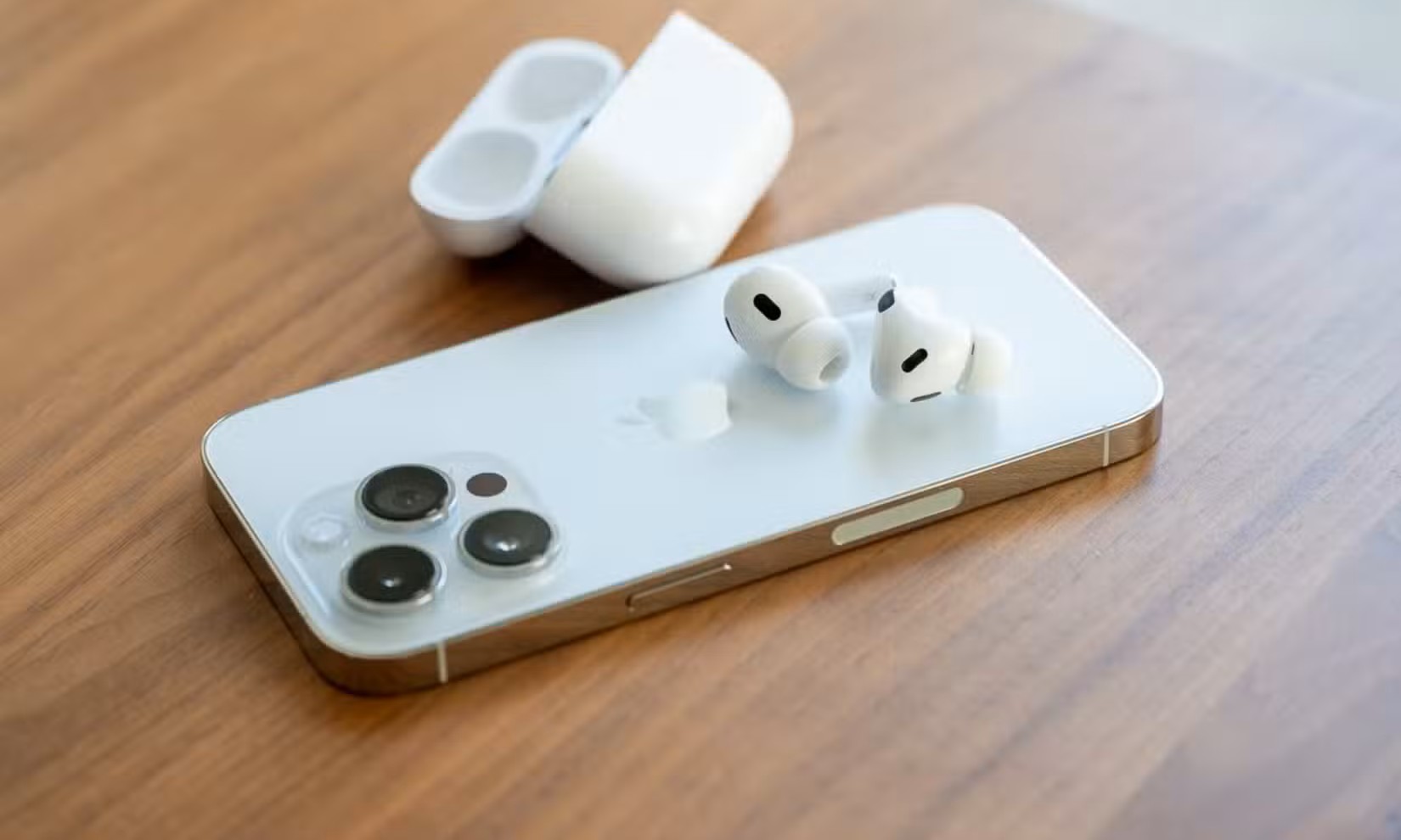Apple AirPods Pro 2. Generation sitzt auf der Rückseite des iPhone 14 Pro.