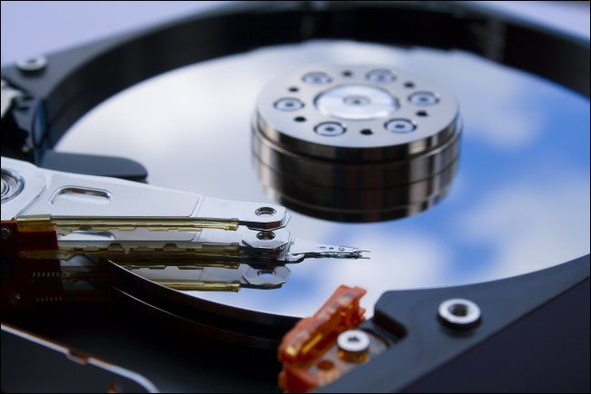 Disques durs Air vs Helio : pourquoi l'hélium gagne en vitesse et en respect de l'environnement ? 🌱⚡ 5 Gros plan du plateau et de la tête d'un disque dur mécanique.