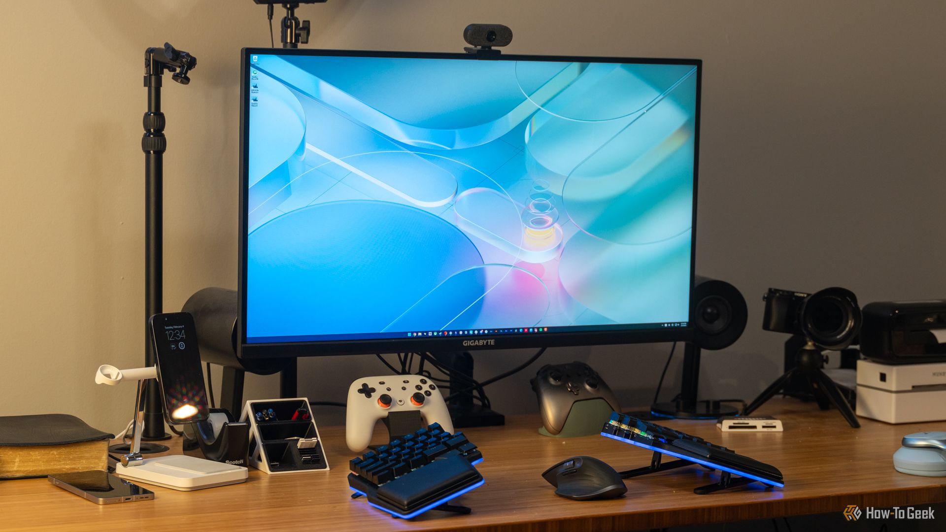 How to Set Up a Mac for Better Gaming: Optimize in 4 Simple Steps ⚡✨ 13 A GIGABYTE M32U 16:9 4K gaming monitor on a desk with a keyboard, controllers, and other accessories.