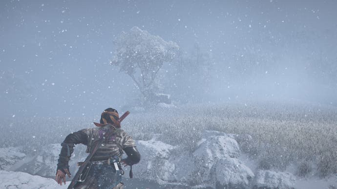 Screenshot da AC Shadows che mostra Naoe che corre attraverso campi di grano innevati con un singolo albero in lontananza