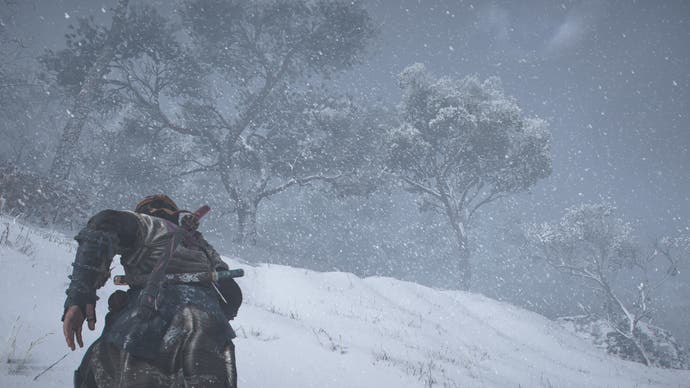 Screenshot da AC Shadows che mostra Naoe che corre giù per una collina innevata verso gli alberi