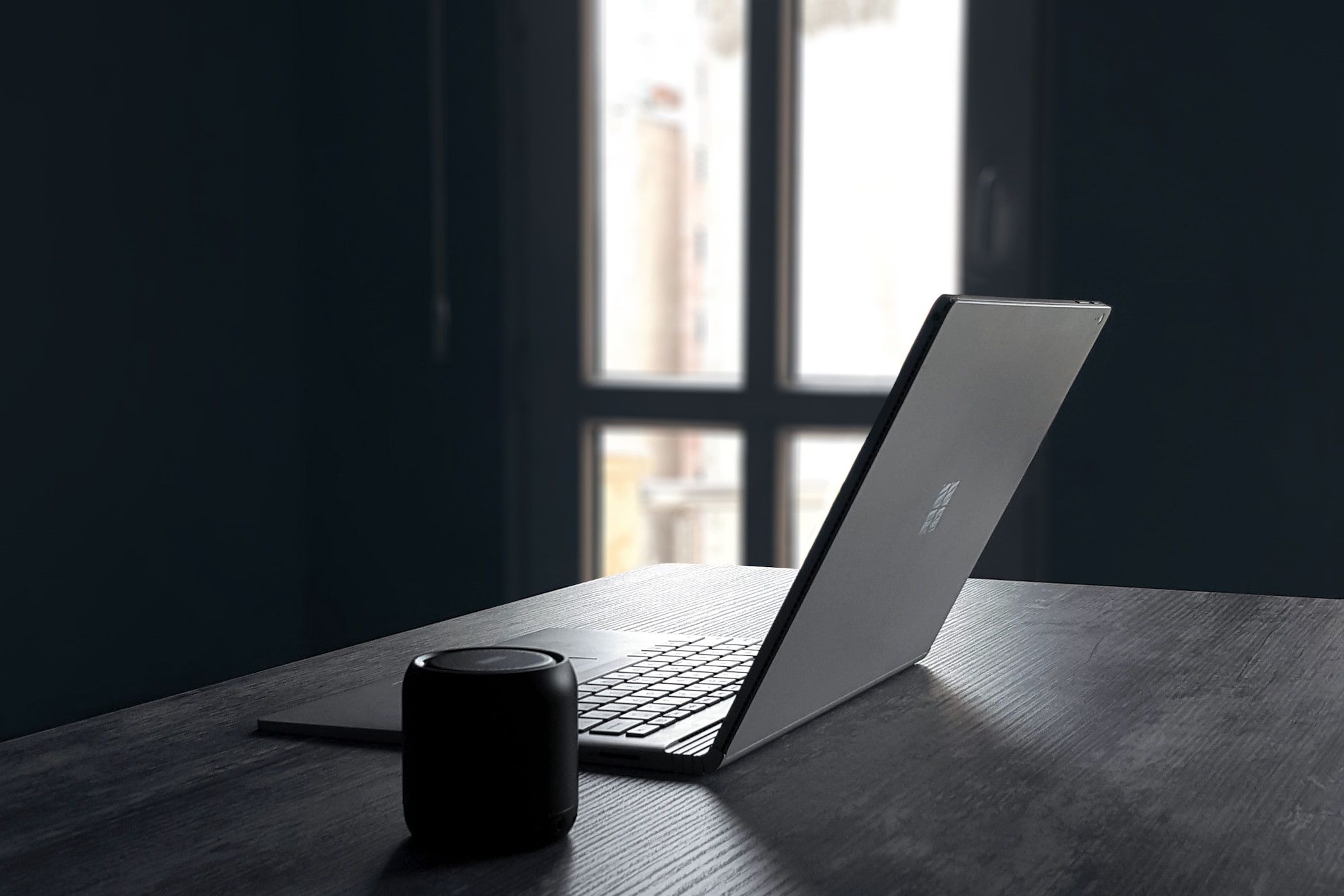 Windows 11-kompatibilitetsläge: Kör spel NU ⚡️ 11 Windows-bärbar dator bredvid en Bluetooth-högtalare på ett bord