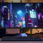 Monitor da gaming ASUS ROG Strix XG27ACMS da 27 pollici con risoluzione QHD e refresh rate a 320 Hz, mostrato su una scrivania da gamer con tastiera e mouse RGB mentre visualizza una scena cyberpunk ad alta definizione.