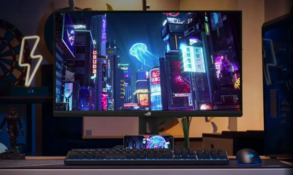 Moniteur de jeu ASUS ROG Strix XG27ACMS 27 pouces QHD avec taux de rafraîchissement de 320 Hz, présenté sur le bureau d'un joueur avec un clavier et une souris RGB affichant une scène cyberpunk haute définition.