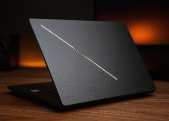 هل جهاز Asus ROG Zephyrus G16 2025 Hybrid ملك اللعب والعمل؟ - نص بديل: "جهاز Asus ROG Zephyrus G16 2025 المحمول الأنيق للألعاب باللون الأسود مفتوح جزئيًا على مكتب خشبي مع شريط إضاءة قطري متوهج على الغطاء، مصمم للألعاب الهجينة وأداء العمل."