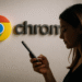 Google Chrome sur Android et sécurité - Une femme utilise un téléphone mobile Android devant un grand logo Google Chrome sur un mur, mettant en évidence la sécurité et la navigation dans Google Chrome sur les appareils Android.