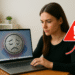 Cómo detectar qué ralentiza Windows en tu PC: Revisa ya. 8 Cómo detectar qué ralentiza Windows en tu PC - Mujer usando un portátil con señal de alerta, investigando cómo detectar qué ralentiza Windows en su PC para solucionar la lentitud y optimizar el rendimiento.
