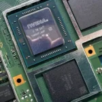 GPU Nintendo Switch 2 - Close-up of Nvidia GPU on Nintendo Switch 2 motherboard, showing graphics processor and memory chips on a green PCB.