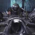 Armas de Doom The Dark Ages: el Doom Slayer apunta cañones dobles desde una máquina de asedio en un entorno oscuro y cavernoso.