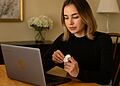 Cara memasangkan AirPods dengan Chromebook: Seseorang membuka casing AirPods dan menghubungkannya melalui Bluetooth ke laptop HP.