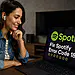 Error 18 Spotify - Mujer usando auriculares mirando su laptop con pantalla de Spotify que muestra el mensaje "Fix Spotify Error Code 18", ilustrando una solución rápida al error 18 de Spotify en Windows.