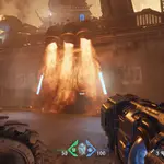 Secreto Puerta de Fuego en Doom The Dark Ages: vista en primera persona con compuerta cubierta de llamas que bloquea el paso, guía para abrirla.