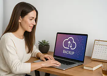 Back-upsoftware - Vrouw gebruikt vandaag back-upsoftware op haar laptop om een ​​back-up te maken naar de cloud en zo te voorkomen dat ze haar gegevens verliest.
