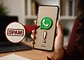 Spam WhatsApp - Telefono cellulare con logo WhatsApp e avviso di spam, che illustra come attivare il filtro antispam nascosto su WhatsApp.