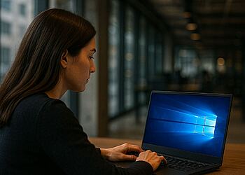 Windows 128-بت - امرأة تستخدم جهاز كمبيوتر محمول بنظام التشغيل Windows في مكتب حديث، مما يوضح القفزة في الأداء والأمان لنظام التشغيل Windows 128-بت الذي يعد بتغيير جهاز الكمبيوتر الخاص بك إلى الأبد.