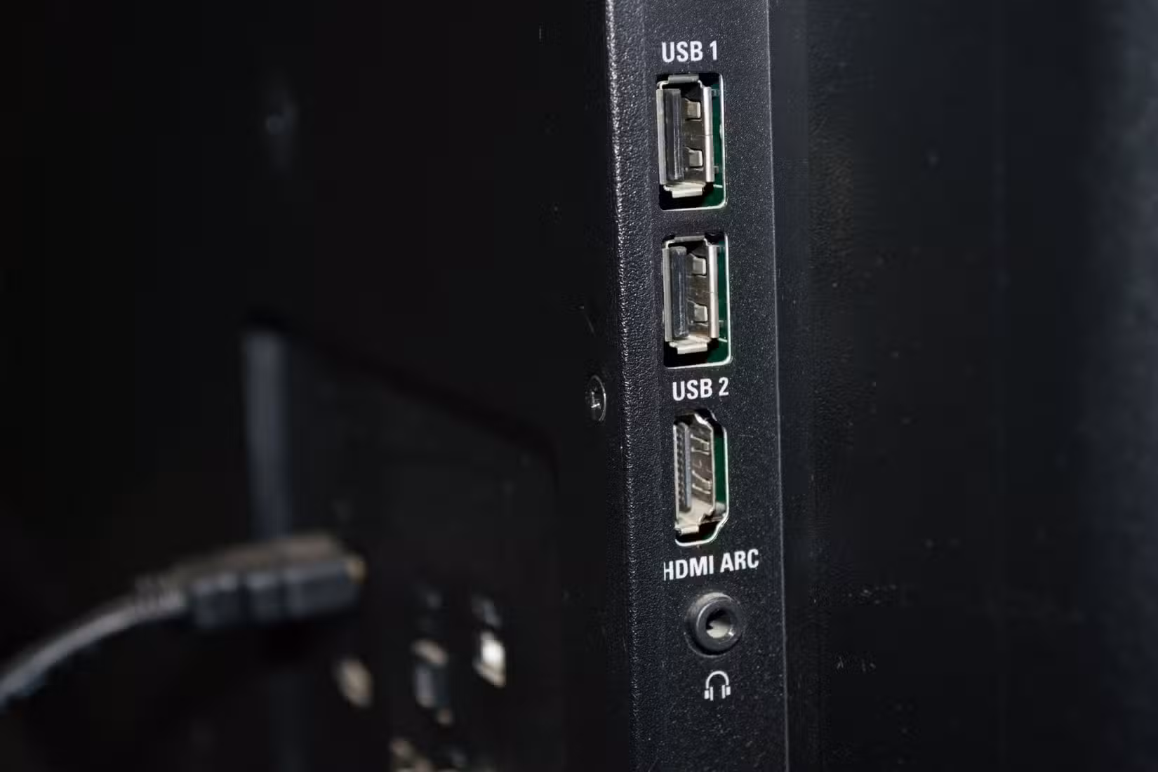 Vue latérale du téléviseur : ports USB, HDMI ARC et sortie casque.
