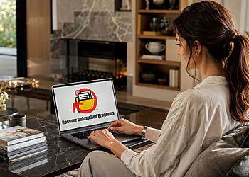 Windows 11'de kaldırılan programlar - Bir kadın, dizüstü bilgisayarını kullanarak Windows 11'de kaldırılan programları geri yüklüyor.